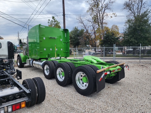 Green Peterbilt tri-axle day cab tractor at the Houston terminal, rear view