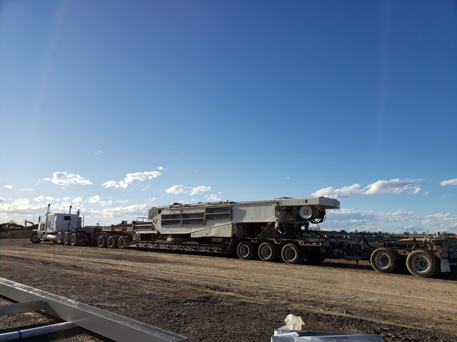 Heavy haul tractor with double drop trailer carrying an oversized industrial machine